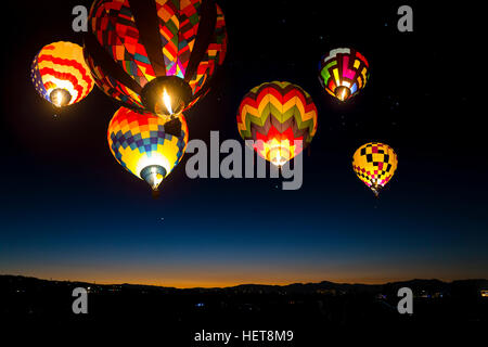 Bunte Heißluftballons in der Morgendämmerung am Himmel leuchtet. Stockfoto