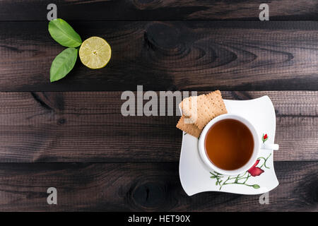 Tasse Tee mit Keksen Tee und frische Limette Stockfoto