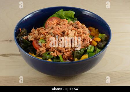 Lachssalat in blau Schüssel mit roter Blattsalat, Paprika, Tomaten und Dosen Wild gefangen Rotlachs Stockfoto