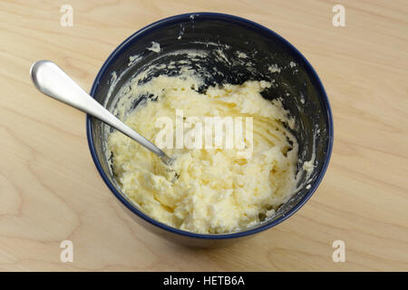 Mischung der Zutaten aus Butter, Frischkäse und Zucker mit Gabel in blau Schüssel mischen. Stockfoto