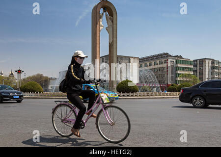 Chinesisches Mädchen mit dem Fahrrad an Kreuzung in Yinchuan, Ningxia, China Stockfoto