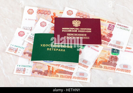 Russische Rente und Veteran Zertifikat liegend über Banknoten. Stockfoto