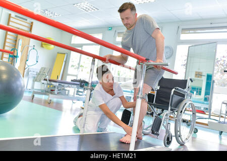 Ergotherapeutin hilft Patienten, zu Fuß Stockfoto