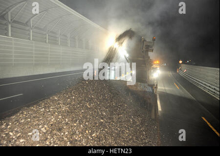 Bissone, Schweiz - 14. September 2007: Arbeiter und Fahrzeuge beim Fräsen Straße von der Autobahn bei Nacht in Bissone, Schweiz Stockfoto