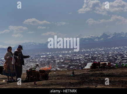 Ein flammender Mesa Opfer zu der Pachamama, Mutter Erde Gottheit außerhalb von La Paz, Bolivien blau bewölktem Himmel und Illumani hinter Stockfoto