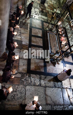 Jerusalem, Israel - 4. Dezember 2013: Franziskaner Mönche beten am Stein der Salbung in der Kirche des Heiligen Grabes in Jerusalem. Stockfoto