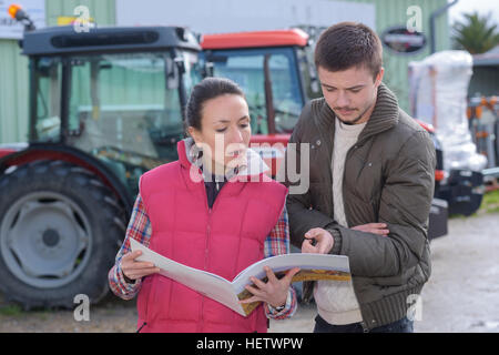 Verkäuferin versuchen, neuen Traktor, Bauer zu verkaufen Stockfoto