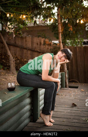 Junge Frau im Freien sitzen, relaxen Stockfoto