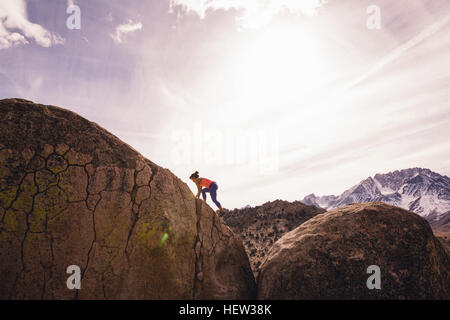 Frau Klettern Fels, Buttermilch Felsbrocken, Bischof, Kalifornien, USA Stockfoto