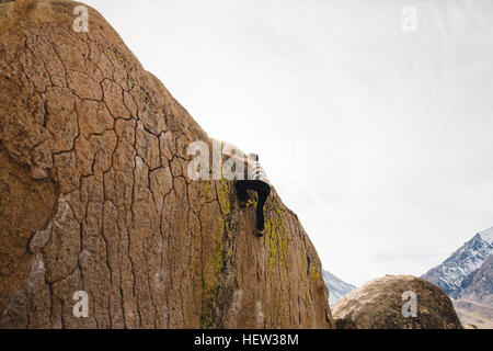 Mann Klettern Felswand, Buttermilch Felsbrocken, Bischof, Kalifornien, USA Stockfoto