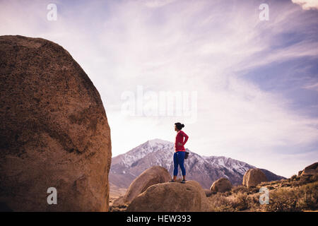 Frau stehend auf Felsen wegsehen, Buttermilch Felsbrocken, Bischof, Kalifornien, USA Stockfoto