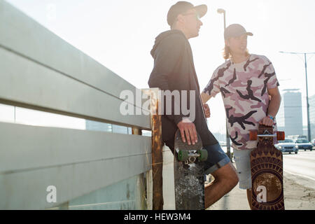 Skateboarder stehen und reden, Budapest, Ungarn Stockfoto