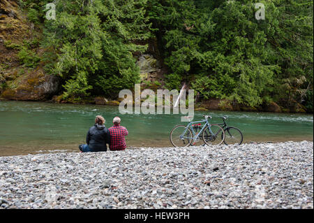 Rückansicht des Paares am Ufer wegsehen, Packwood, Washington, USA Stockfoto