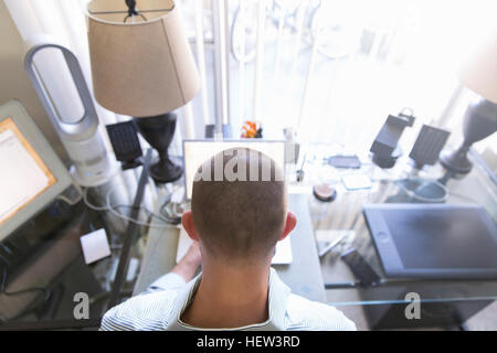 Rückansicht des Menschen tippen auf Laptop, arbeiten von Zuhause Stockfoto