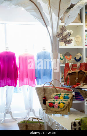 Reihe von bunten Blusen Kleider Schiene im Mode-Boutique-Fenster Stockfoto