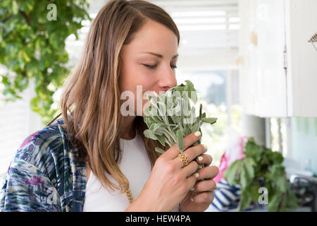 Frau riechen frische Kräuter Stockfoto