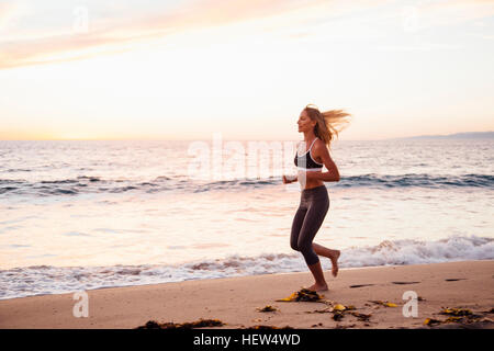 Frau am Strand joggen Stockfoto