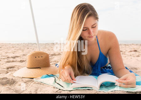 Junge Frau Buch am Strand lesen Stockfoto