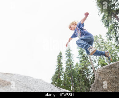 Kleiner Junge abspringen Rock, niedrigen Winkel Ansicht, Sequoia Nationalpark, Kalifornien, USA Stockfoto