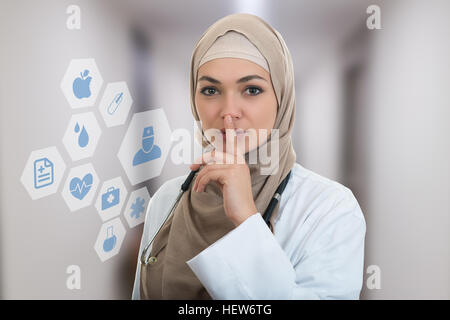 Closeup Portrait von freundlichen, zuversichtlich Muslim mit Hijab Arzt zeigt shh Seufzer, Stille. Stockfoto