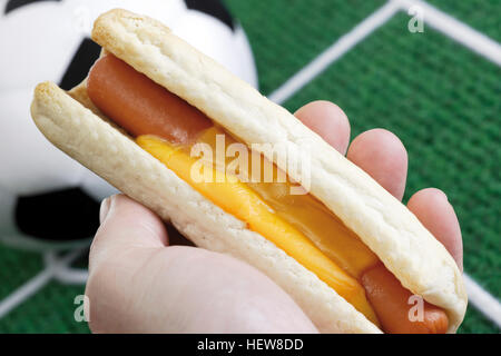 Hand, die Hot-Dog, Fußball und Tonhöhe Stockfoto