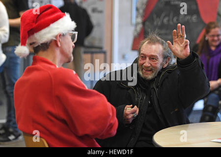 Eine Krise volunteer Gespräche zu einem Obdachlosen Besucher auf der diesjährigen Krise im Weihnachten Centre in London, die während der Weihnachtszeit geöffnet werden. Stockfoto