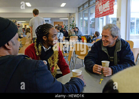 Eine Krise volunteer Gespräche zu einem Obdachlosen Besucher auf der diesjährigen Krise im Weihnachten Centre in London, die während der Weihnachtszeit geöffnet werden. Stockfoto