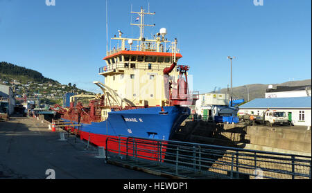 Der Hopper Dredger, der in den Niederlanden unter Flagge gehalten wird, befindet sich im Trockendock im Hafen von Lyttleton, Neuseeland. Das Schiff, das für Baggerarbeiten eingesetzt wird, hat eine Bruttoraumzahl von 2.176 Tonnen und eine Tragfähigkeit von 3.200 Tonnen. Sie wurde 1996 erbaut und ist an der Erhaltung von Navigationskanälen beteiligt, indem sie Sedimente aus den Wasserstraßen entfernt. Stockfoto