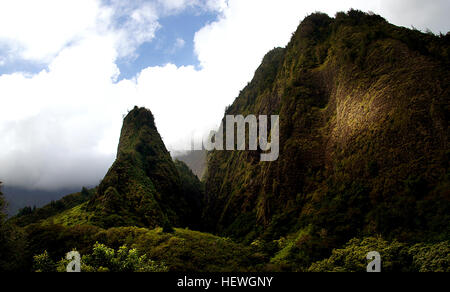 Smaragdene hoch aufragenden Gipfeln bewachen den üppigen Talboden des Iao Valley State Park. Im Central Maui gerade westlich von Wailuku, dieser friedlichen 4.000 Hektar großen, 10 Meilen langen Park ist Heimat einer der markantesten Wahrzeichen von Maui, die 1.200 Fuß Iao Nadel. Dieses kultige grün Jaguaren Felsen zu Tage tretenden überblickt Iao Stream und ist eine ideale Attraktion für einfache Wanderungen und Besichtigungen. Stockfoto