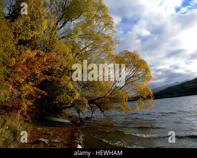 Lake Hayes ist ein kleiner, malerischer See auf Neuseelands Südinsel, der sich in der Nähe von Arrowtown und Queenstown befindet. Der See ist bekannt für seine wunderschönen Herbstfarben und bietet malerische Ausblicke auf die umliegenden Landschaften, besonders während der Herbstsaison, wenn die Bäume goldfarben sind. Stockfoto