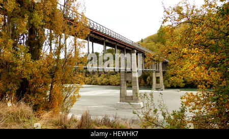 Befindet sich 10 km von Queenstown (Highway 6), die alte untere Shotover Brücke wurde 1871 erbaut und bietet Fuß Verkehr auffälligen 360 Panoramablick auf dem Shotover River.  Die ursprüngliche Brücke war im Jahre 1878 von Hochwasser weggespült aber von Public Works Department umgebaut und neu eröffnet im Jahr 1915. Die Brücke is172 Meter lang und stands16 Meter von der Brücke auf dem Fluss unten. Stockfoto