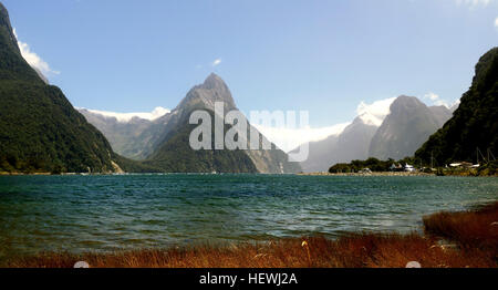 Milford Sound führt 15 km landeinwärts von der Tasmansee an Dale Punkt (auch benannt nach einem Ort in der Nähe von Milford Haven in Wales) - die Mündung des Fjordes - und ist umgeben von steilen Felswänden, die 1.200 Meter (3.900 ft) zu erheben oder mehr auf beiden Seiten. Zwischen den Gipfeln sind The Elephant auf 1.517 m (4.977 ft), sagte ein Elefant Kopf, [6] und The Lion, 1.302 m (4.272 ft), ähneln in der Form eines kauernden Löwen.   Milford Sound Sport zwei permanente Wasserfälle ganzjährig, Lady Bowen Falls und Stirling fällt. [8] nach schweren Regen Sie, viele Hunderte von temporären Wasserfälle Stockfoto