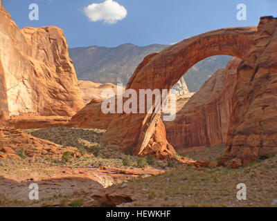 Dieses Foto fängt die atemberaubende Landschaft des Lake Powell und das Rainbow Bridge National Monument in Utah ein. Das Bild hebt den berühmten Steinbogen hervor, eine natürliche Formation, die zu einem beliebten Aussichtspunkt geworden ist. Die Regenbogenbrücke, bekannt für ihre unverwechselbare Form und leuchtende Farben, ist ein Zeugnis der geologischen Wunder der Region. Stockfoto
