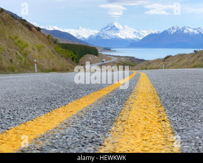 Die landschaftlich reizvolle Fahrt zum Mount Cook National Park bietet 55 km von See, Berg und Busch-Landschaft. Lernen Sie, wie man dorthin und sehen ein Video vom Aussehen der Landschaft.  Diese landschaftlich reizvolle Fahrt beginnt an der Kreuzung der Autobahnen 8 und 80.  Es ist ca. 55 km ab Autobahn 80 bis zur Kreuzung mit der Hooker Valley Road im Mount Cook National Park.  Fahren bei ca. 80 bis 100 km/h (50 bis 62 mph) – die zulässige Höchstgeschwindigkeit auf Autobahnen in Neuseeland ist 100 km/h (62 mph) – es dauert etwa 30 bis 40 Minuten, Mount Cook National Park von der Kreuzung mit dem Highway 8 zu erreichen. Stockfoto