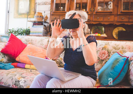 Frau auf Sofa mit virtual-Reality-Kopfhörer Stockfoto