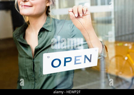 Frau platzieren offene anmelden Glastür Stockfoto