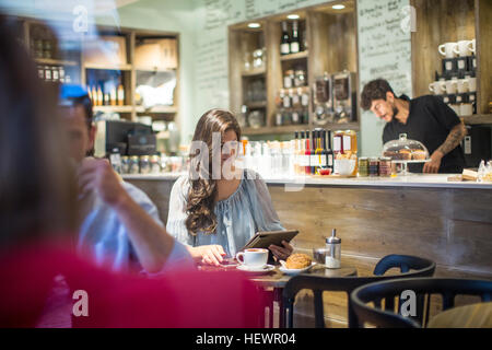 Junge Frau betrachten digitaler Tablet im café Stockfoto