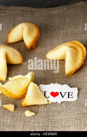 Cookies mit dem Wort Liebe auf ein Papier geschrieben wie Tortellini geformt. Vertikales Bild. Stockfoto