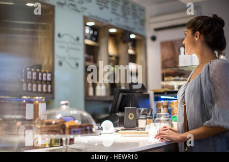 Junge Frau wartet am Café-Schalter Stockfoto