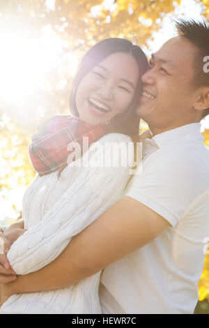 Junges Paar umarmt im sonnigen herbstlichen Park, Peking, China Stockfoto