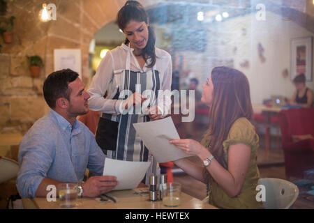 Kellnerin serviert Kunden im restaurant Stockfoto