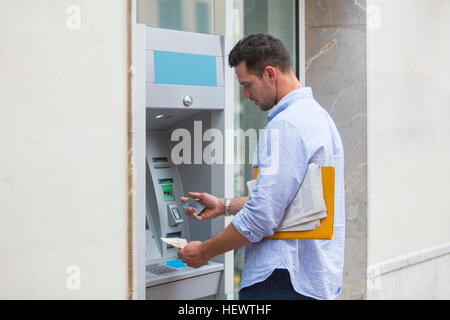 Man Bargeld von Geldautomaten Stockfoto