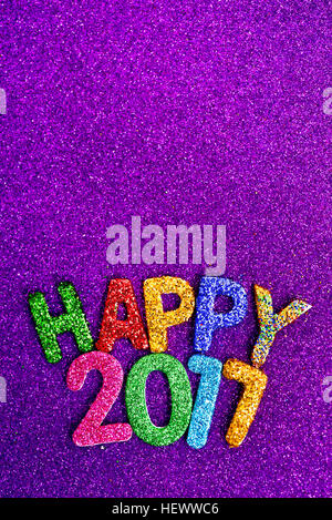 Nahaufnahme von einige glitzernden Buchstaben in verschiedenen Farben bilden den Text gerne 2017 auf einem violetten glitzernden Hintergrund durch ein Leerzeichen in den top Stockfoto