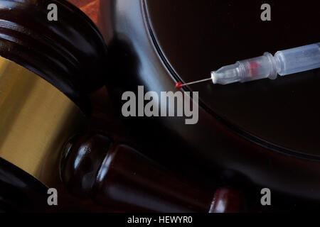 Hammer und Spritze auf einem Holztisch. Stockfoto