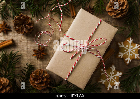 Weihnachtsgeschenk verpackt in Kraftpapier umgeben von natürlichen d Stockfoto