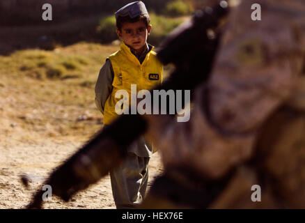 Ein afghanischer Junge beobachtet, wie ein Marine-Kampfingenieur mit Ingenieur-Unternehmen, Bekämpfung Logistik-Bataillon 3, Patrouillen 1st Marine Logistics Group (vorwärts) in der Nähe von Patrol Base Amir, Afghanistan, November 28. Ca. 50 Marinesoldaten mit CLB-3 Ingenieur Unternehmen abgeschlossen Meilen des Straßennetzes in der afghanischen Provinz Helmand. Ebnet den Weg, Verbesserung der CLB-3 Ingenieure Straße im südlichen Afghanistan-DVIDS346387 Stockfoto