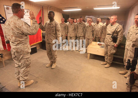 Chief Warrant Officer Three William Slay, rezitiert den Offizier Amtseid, geliefert von Oberst Paul J. Kennedy, Kommandierender Offizier der Regimental Combat Team 2, während seine Kollegen Stabsoffiziere während seiner Förderung-Zeremonie an Bord der Forward Operating Base Delaram II, stramm stehen Nimruz Provinz, Afghanistan, 12. Dezember 2010.  Tötest, ein Alabama stammende Chicago berufliche Gymnasium besucht und ist derzeit verfolgt einen Abschluss in Psychologie. Er diente in der US-Marine Corps seit 15 Jahren und ist derzeit im Einsatz mit RCT-2 als ihre Regiments Instandhaltungsmanagement, Artillerie und Feld mich Stockfoto