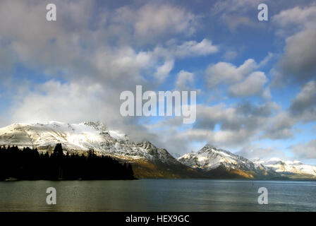 Dieses von einer DSLR A300 von Sony aufgenommene Foto zeigt den Wakatipu-See im Winter mit schneebedeckten Bergen und dramatischen Wolkenformationen. Das Bild in Queenstown, Otago, vermittelt die ruhige Schönheit dieser berühmten Landschaft Neuseelands. Stockfoto