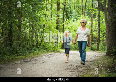 Großmutter und Enkel im Wald Hand in Hand gehen Stockfoto