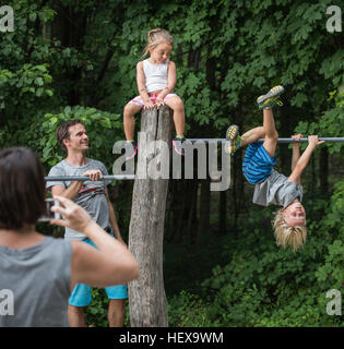 Mutter, die Kinder spielen am Monkey Bar zu fotografieren Stockfoto